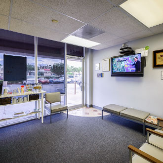 Front lobby with chairs and tv at Bisel Hearing Aid Center
